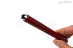 a person holding a red pen in their hand