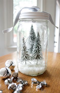 a jar filled with snow and silver bells