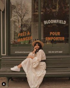 a woman sitting on a bench in front of a store