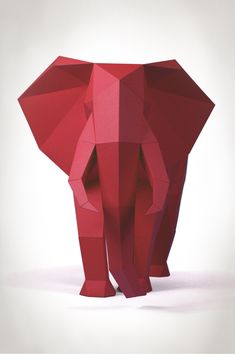 an elephant made out of red paper on a white background with the head turned to the side