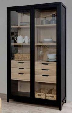 a black cabinet with glass doors and wicker baskets