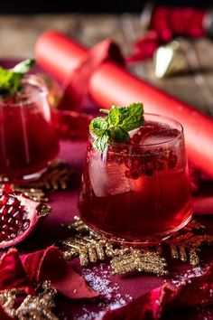 two glasses of pomegranate drink on a table with red cloth and gold decorations