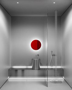 a bathroom with a red circle on the wall and a silver sink in front of it