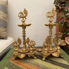 two golden candlesticks sitting on top of a rug