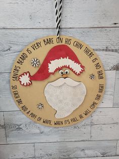 a christmas ornament hanging on the side of a wooden wall with a message