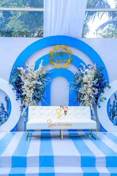 a blue and white striped table cloth with flowers on it is set up for a ceremony