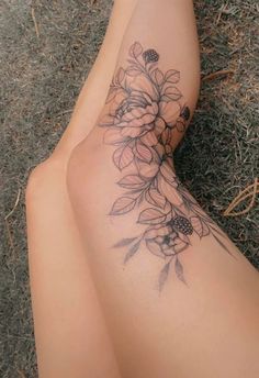 a woman's legs with flowers tattooed on the top and bottom of her leg