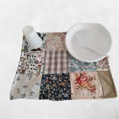 a plate, fork and cup on a patchwork table cloth