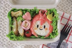 a plastic container filled with food and a fork on top of a table next to a napkin