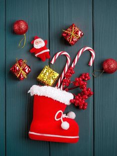 christmas decorations and candy canes on a blue wooden background with santa's stocking