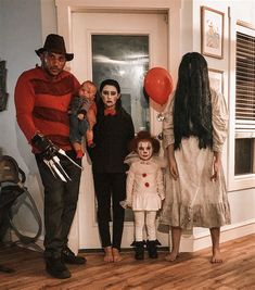 a group of people standing next to each other in front of a door with balloons