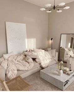 a living room filled with lots of white furniture and pillows on top of a couch