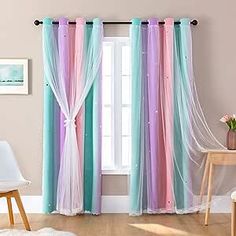 the curtains are hanging in front of the window with white drapes and pink, blue, and green colors