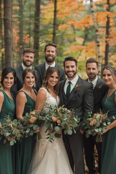 a group of people standing next to each other in front of trees with leaves on them