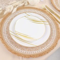 a white plate with gold trim and fringes on it, sitting on a table