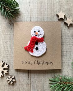 a christmas card with a crocheted snowman on it