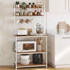 a kitchen with white cabinets and wooden shelves filled with food on top of the counter