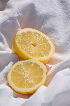 two lemons cut in half on a white cloth