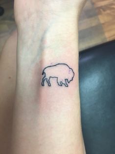 a small pig tattoo on the wrist