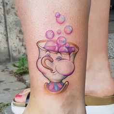 a woman's leg with an elephant in a pot tattoo on her left side