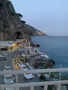 an outdoor restaurant overlooking the ocean at dusk