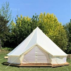 a large white tent sitting on top of a lush green field