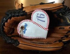 a baseball glove with a heart shaped ornament on it