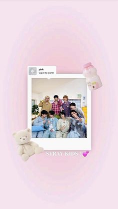 a group of people sitting on top of a couch next to a teddy bear in front of a pink wall