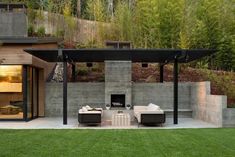 an outdoor living area with couches and tables in the foreground, surrounded by grass