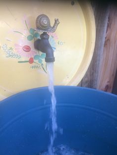 a water faucet that is pouring out of a blue bowl