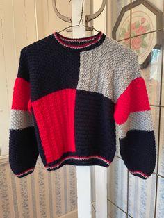 a multicolored sweater hanging from a hook