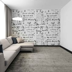 a living room with a large couch and wallpaper on the walls that has writing all over it