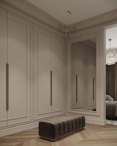 an empty room with white closets and chandelier hanging from the ceiling next to a bed