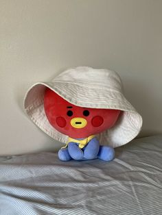 a stuffed animal wearing a hat on top of a bed