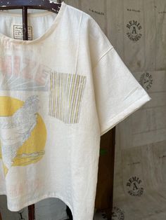 Handmade, one of a kind t shirt made using a vintage feedsack and apron from the 1940s. Very lightweight and breezy cotton. Pocket tee and striped sleeve detail. Please note there are areas of light staining, discoloration, and small distressed areas. Can fit a size small or medium best, or can be worn oversized. Has a boxy, slightly cropped fit. Gender neutral. All sales are final, so please refer to measurements and look carefully through the photos. Please feel free to reach out with any ques Vintage Cotton T-shirt With Relaxed Fit, Cream Vintage Relaxed Fit T-shirt, Relaxed Fit T-shirt With Patch Pockets And Short Sleeves, Cotton T-shirt With Patch Pockets, Short Sleeve, Vintage Cotton Pre-shrunk T-shirt, Western Farmhouse, Feed Sacks, Striped Sleeve, Pocket Tee