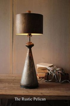 a table lamp sitting on top of a wooden table next to a stack of books