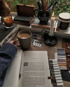 a person sitting at a table with some books and coffee mugs on top of it