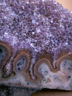 a close up view of some kind of rock with purple and white crystals on it