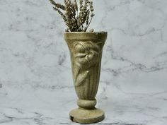 there is a vase with flowers in it on the marble counter top and white marble background