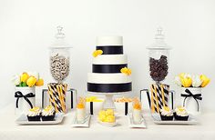 a table topped with lots of different types of cakes and desserts covered in black and white stripes