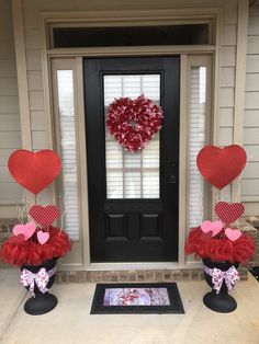 two valentine's day decorations in front of a door with a heart shaped wreath