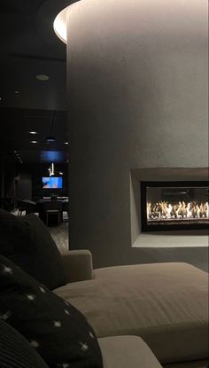 a living room filled with furniture and a fire place next to a wall mounted tv