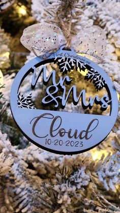 a personalized ornament hanging from a christmas tree with snowflakes on it