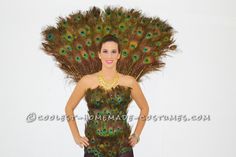 a woman dressed as a peacock with feathers on her head and body, standing in front of a white background