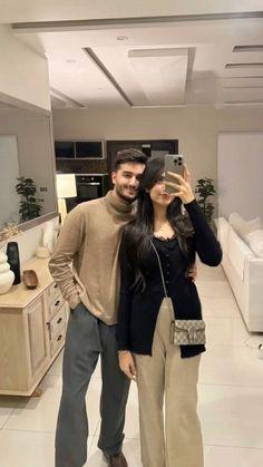 a man and woman taking a selfie in a living room with white tile flooring