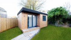 a small wooden shed sitting on top of a lush green field