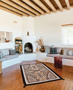 a living room filled with furniture and a fire place in the middle of a room