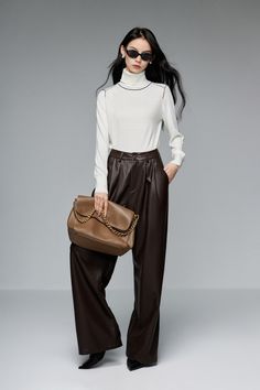 Elevated Style: Straight-Leg, Slimming Casual Leather Pants Welcome the chilly season with our new PU leather pants, boasting a straight leg cut and minimalist style that's essential for your wardrobe. Crafted from selectively sourced stretchy PU leather, these pants offer the perfect thickness for warmth and comfort without bulkiness. The high-waisted design gracefully elongates the legs, ensuring a slimming effect whether you're navigating the urban jungle or your office corridors. Meticulous Brown High-waisted Leather Pants For Winter, Brown Leather Trousers For Winter, Winter Wide Leg Faux Leather Pants, Leather Straight Pants For Winter, Brown Office Pants For Fall, Trendy Faux Leather Pants For Winter, Winter Office Brown Bottoms, Office Straight Faux Leather Pants, Brown Leather Trousers For Fall