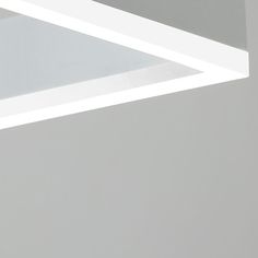 a close up of a white light fixture on a gray wall with no lighting in it