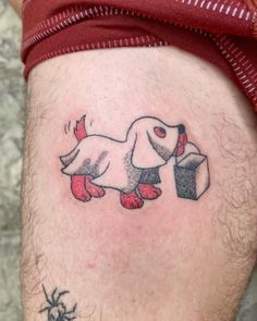 a man's leg with a tattoo of a dog carrying a box